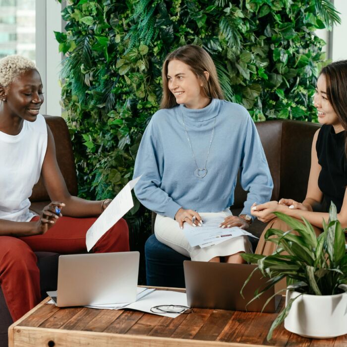 Frauen sitzen an einem Couchtisch und besprechen Arbeitsergebnisse